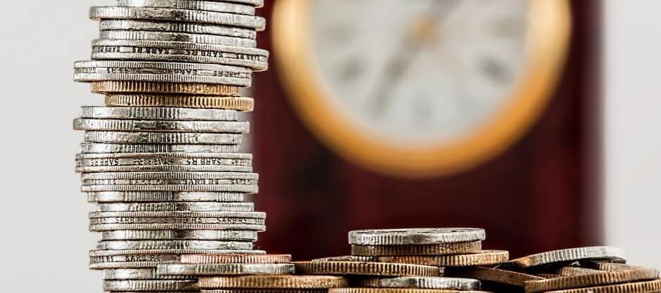 Coins in front of a clock